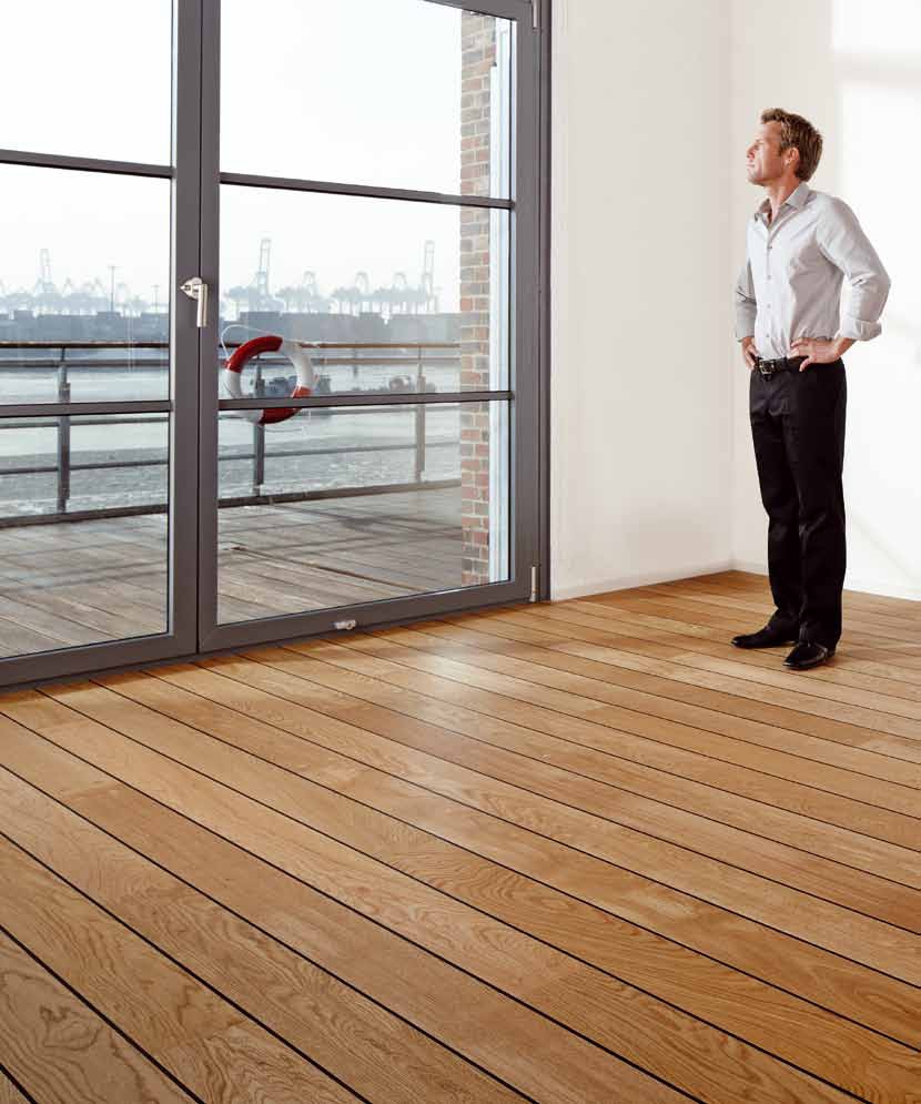 Mężczyzna stoi w pokoju z drewnianą podłogą